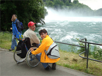 Rollstuhlfahrer mit Begleiter betrachtet den Rheinfall